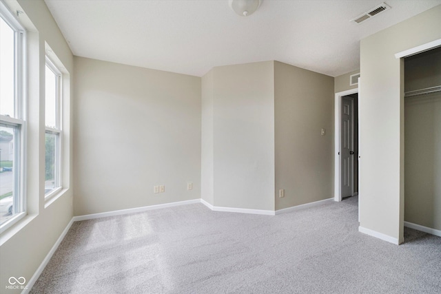 2834 Wolfgang Dr, Indianapolis, IN 46239 - unfurnished bedroom featuring multiple windows, light carpet, and baseboards