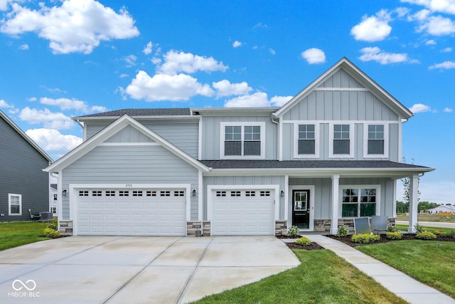 2733 Bo St W, Plainfield, IN 46168 - view of front of property with board and batten siding, concrete driveway, covered porch, a front lawn, and stone siding