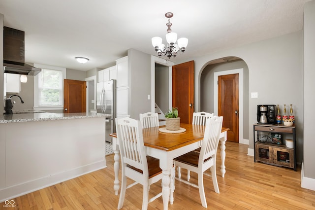 110 E Harrison St, Spiceland, IN 47346 - dining room with arched walkways, light wood-style flooring, and a chandelier