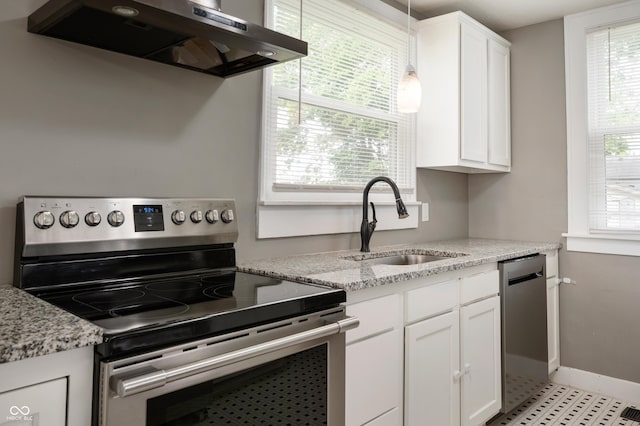 110 E Harrison St, Spiceland, IN 47346 - kitchen with appliances with stainless steel finishes, exhaust hood, healthy amount of natural light, and white cabinetry