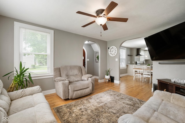 110 E Harrison St, Spiceland, IN 47346 - living area featuring ceiling fan, arched walkways, and light wood-style floors