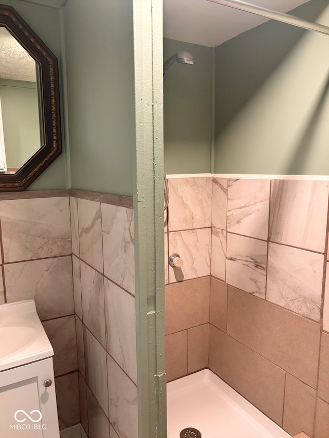 624 N Rural St, Indianapolis, IN 46201 - bathroom with tile walls, vanity, wainscoting, and tiled shower