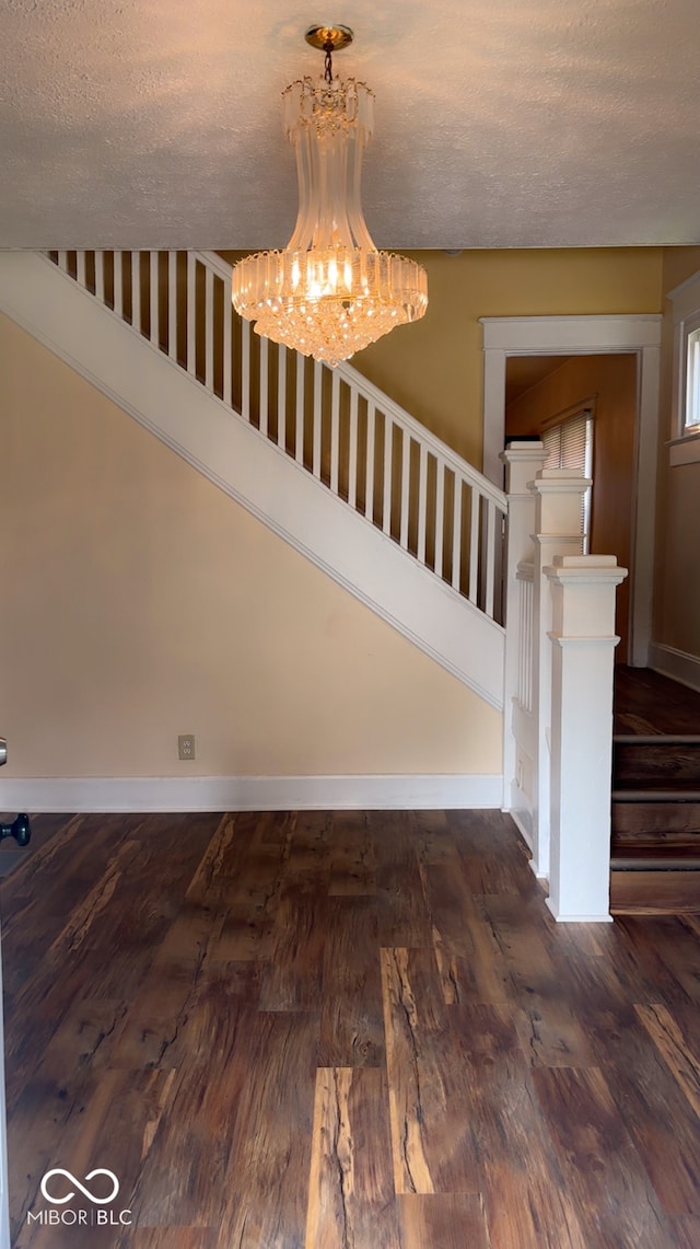 624 N Rural St, Indianapolis, IN 46201 - staircase featuring a chandelier, wood finished floors, a textured ceiling, and baseboards