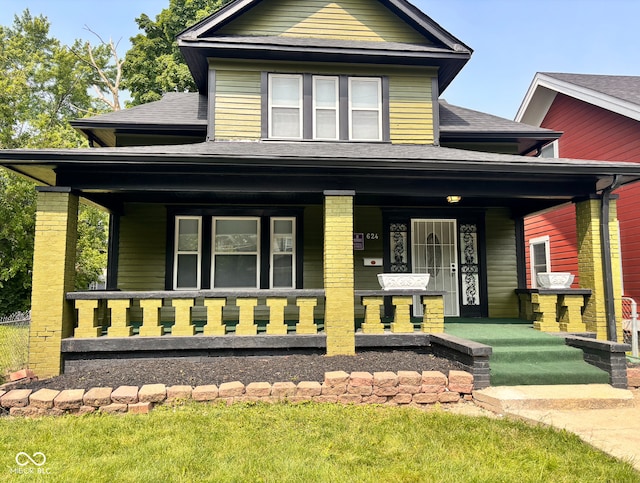 624 N Rural St, Indianapolis, IN 46201 - view of front facade with covered porch, roof with shingles, and a front yard