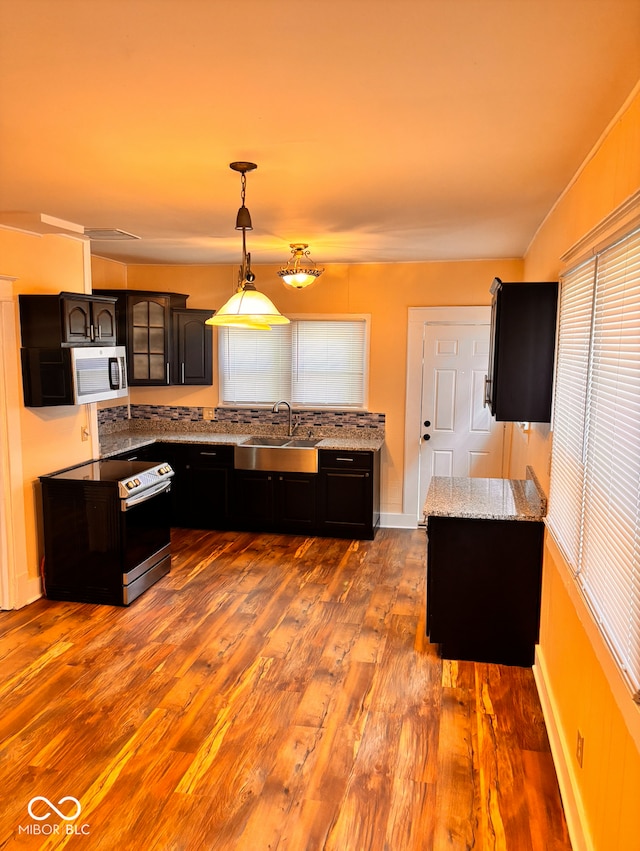 624 N Rural St, Indianapolis, IN 46201 - kitchen featuring a sink, appliances with stainless steel finishes, wood finished floors, light stone counters, and pendant lighting
