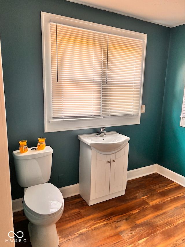 624 N Rural St, Indianapolis, IN 46201 - half bathroom with baseboards, toilet, wood finished floors, and vanity