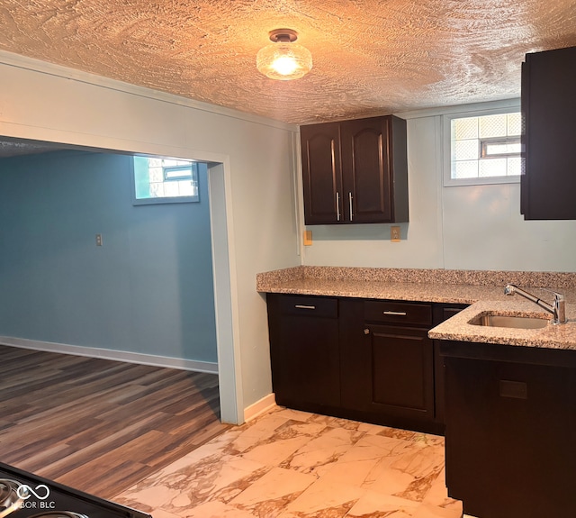 624 N Rural St, Indianapolis, IN 46201 - kitchen featuring a sink, light marble finish floors, dark brown cabinets, and light stone countertops