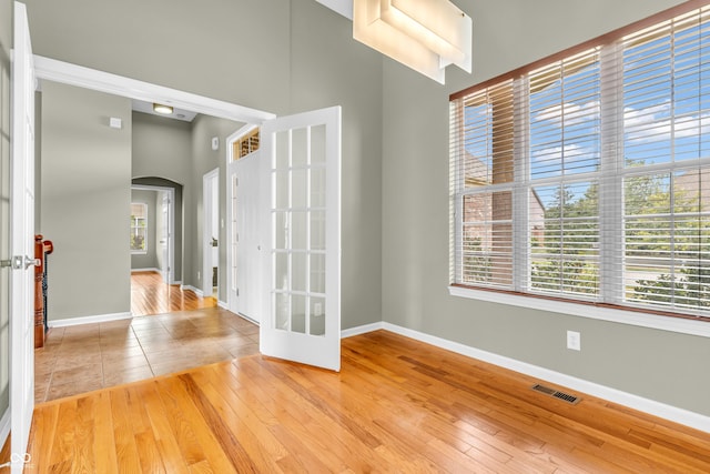 2948 Chalbury Dr, Plainfield, IN 46168 - spare room with arched walkways, a towering ceiling, and hardwood / wood-style flooring