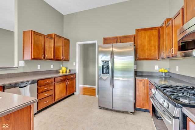 2948 Chalbury Dr, Plainfield, IN 46168 - kitchen with stainless steel appliances, brown cabinetry, and dark countertops