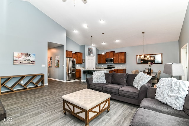 5439 Maywood Dr, Whitestown, IN 46075 - living room with wood finished floors, a chandelier, baseboards, a ceiling fan, and high vaulted ceiling