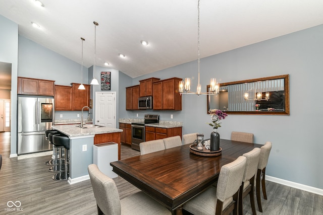 5439 Maywood Dr, Whitestown, IN 46075 - dining room featuring wood finished floors, a chandelier, high vaulted ceiling, and baseboards