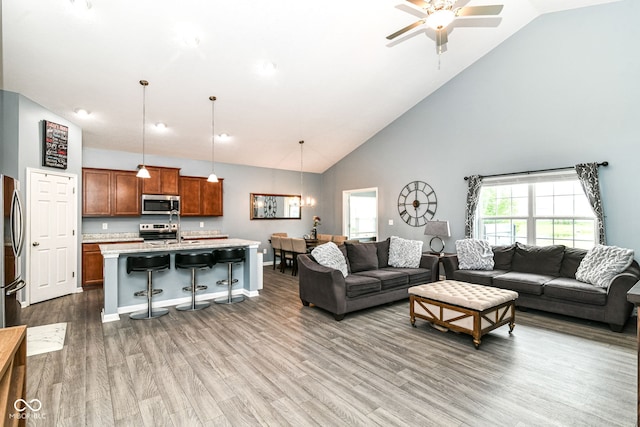 5439 Maywood Dr, Whitestown, IN 46075 - living area with high vaulted ceiling, a ceiling fan, wood finished floors, and a chandelier