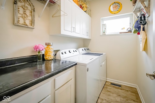 4305 W Coyote Run Ct, Muncie, IN 47304 - laundry area featuring washing machine and dryer, wood finished floors, cabinet space, and baseboards