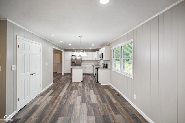 9378 N County Road 75 W, Lizton, IN 46149 - kitchen with appliances with stainless steel finishes, ornamental molding, dark wood-style flooring, white cabinets, and a kitchen island