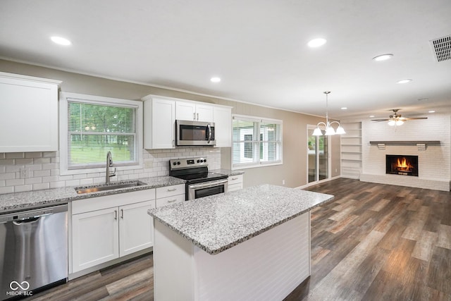 9378 N County Road 75 W, Lizton, IN 46149 - kitchen with stainless steel appliances, a sink, a brick fireplace, open floor plan, and dark wood-style floors