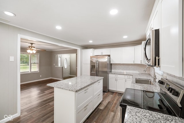 9378 N County Road 75 W, Lizton, IN 46149 - kitchen featuring appliances with stainless steel finishes, crown molding, dark wood-type flooring, a center island, and decorative backsplash