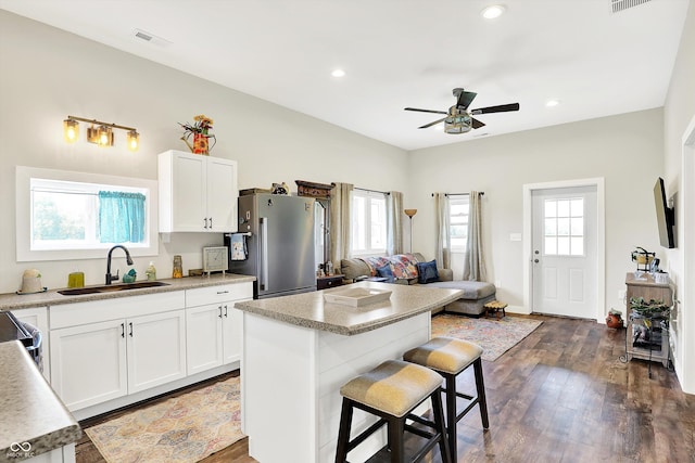 3301 N 200 W, Franklin, IN 46131 - kitchen with stainless steel appliances, a sink, ceiling fan, a breakfast bar area, and dark wood-type flooring
