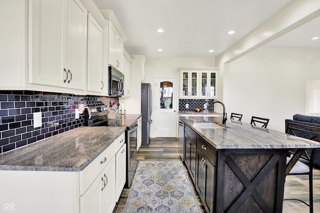3301 N 200 W, Franklin, IN 46131 - kitchen featuring appliances with stainless steel finishes, a sink, a breakfast bar, wood finished floors, and tasteful backsplash