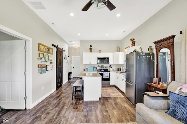 3301 N 200 W, Franklin, IN 46131 - kitchen with appliances with stainless steel finishes, a barn door, a kitchen island, a ceiling fan, and a kitchen bar
