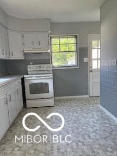 2028 Gilmore St, Columbus, IN 47201 - kitchen featuring electric stove, under cabinet range hood, white cabinetry, and light countertops