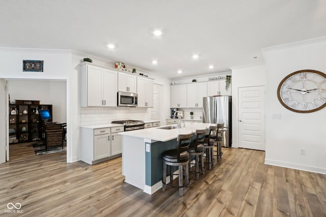 11429 Lottie Cir, Noblesville, IN 46060 - kitchen with appliances with stainless steel finishes, a kitchen bar, decorative backsplash, light wood-type flooring, and recessed lighting