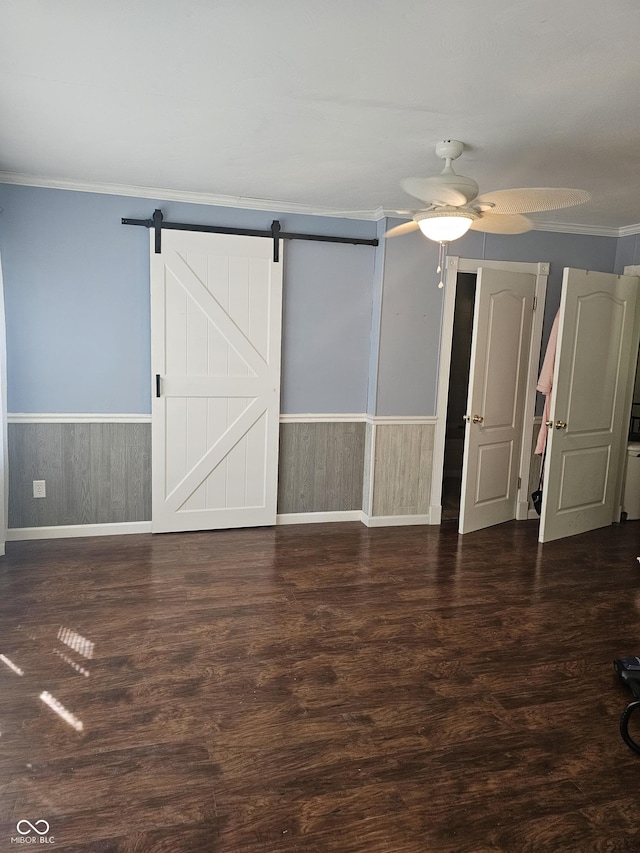 1317 S Ebert Dr, Rockville, IN 47872 - unfurnished bedroom featuring crown molding, wainscoting, wood finished floors, a barn door, and ceiling fan