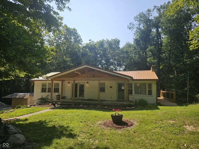 1317 S Ebert Dr, Rockville, IN 47872 - view of front of house with a front yard, a chimney, a metal roof, and covered porch