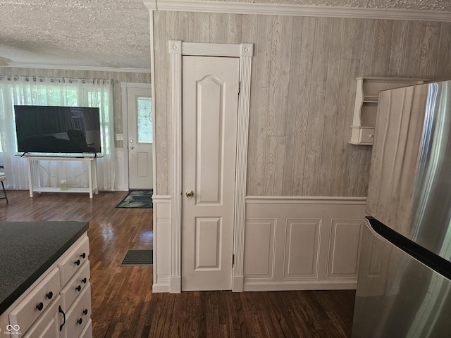 1317 S Ebert Dr, Rockville, IN 47872 - kitchen featuring freestanding refrigerator, dark wood finished floors, a textured ceiling, wood walls, and white cabinetry