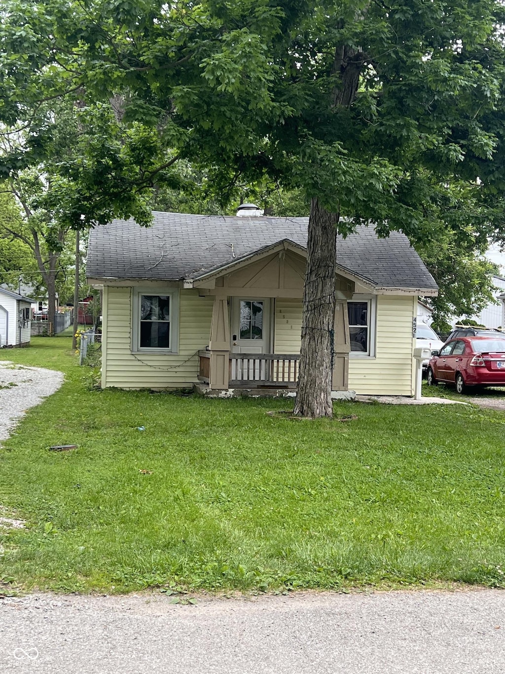4521 Vernon Ave, Indianapolis, IN 46226 - bungalow-style home featuring a porch, a front lawn, a chimney, and a shingled roof