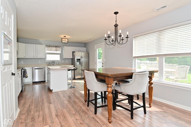 15524 Follow Dr, Noblesville, IN 46060 - dining room featuring light wood-style flooring, a chandelier, and baseboards