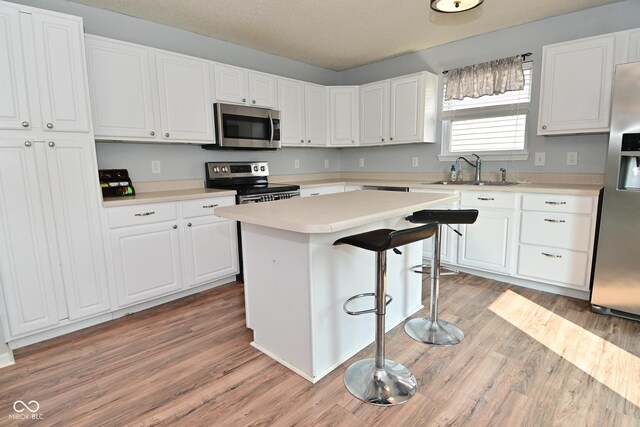 15524 Follow Dr, Noblesville, IN 46060 - kitchen featuring stainless steel appliances, a sink, white cabinets, and light wood-style flooring