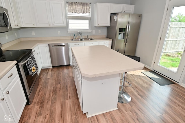 15524 Follow Dr, Noblesville, IN 46060 - kitchen with stainless steel appliances, a sink, wood finished floors, and white cabinetry