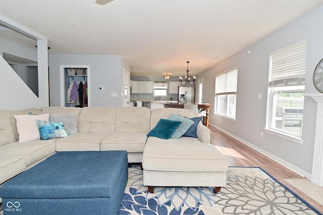 15524 Follow Dr, Noblesville, IN 46060 - living room featuring a chandelier, light wood-style floors, and baseboards