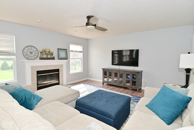 15524 Follow Dr, Noblesville, IN 46060 - living room with a fireplace, wood finished floors, a ceiling fan, a textured ceiling, and baseboards