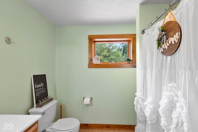 6800 N County Road 100 E, Seymour, IN 47274 - full bath with toilet, vanity, tile patterned flooring, baseboards, and a textured ceiling