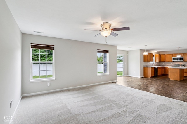 1739 Wedgewood Pl, Avon, IN 46123 - unfurnished living room featuring plenty of natural light, a ceiling fan, and dark colored carpet