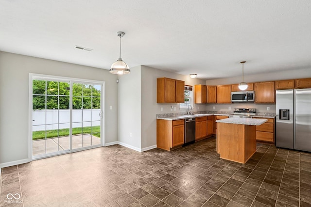 1739 Wedgewood Pl, Avon, IN 46123 - kitchen with stainless steel appliances, brown cabinets, decorative light fixtures, and a kitchen island