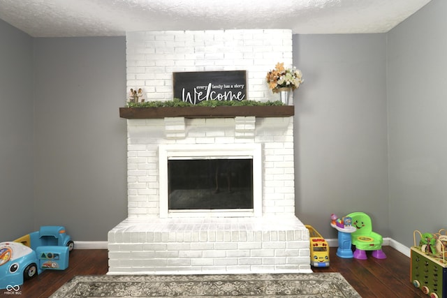 3119 W Burning Tree Rd, Crawfordsville, IN 47933 - living room featuring wood finished floors, baseboards, a textured ceiling, and a fireplace