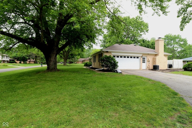 3119 W Burning Tree Rd, Crawfordsville, IN 47933 - view of front facade with asphalt driveway, a chimney, a garage, a front lawn, and central AC