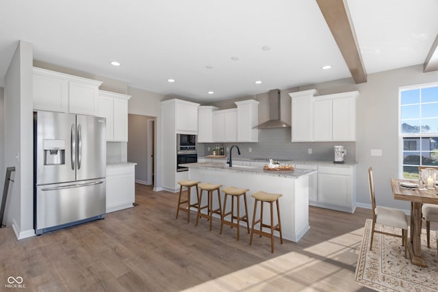 4995 S 650 W, Jamestown, IN 46147 - kitchen featuring appliances with stainless steel finishes, wall chimney exhaust hood, a sink, decorative backsplash, and light wood-style floors