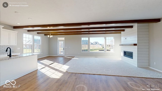4995 S 650 W, Jamestown, IN 46147 - unfurnished living room with beam ceiling, wood finished floors, baseboards, a large fireplace, and healthy amount of natural light