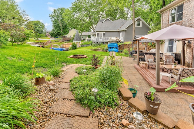 101 Jefferson Vly, Coatesville, IN 46121 - view of green lawn featuring a wooden deck, an outdoor living space with a fire pit, and a patio