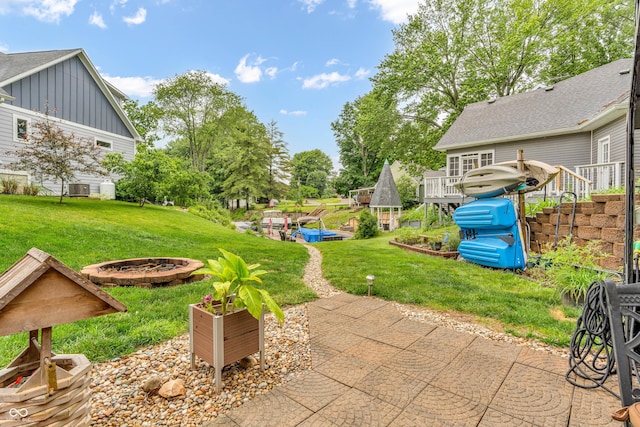 101 Jefferson Vly, Coatesville, IN 46121 - view of grassy yard featuring a fire pit, a patio, and a deck