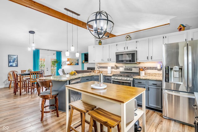 101 Jefferson Vly, Coatesville, IN 46121 - kitchen with appliances with stainless steel finishes, a peninsula, a chandelier, tasteful backsplash, and pendant lighting