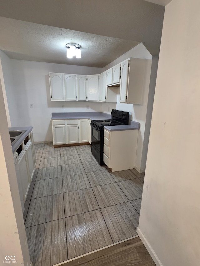 6368 Titania Dr, Indianapolis, IN 46236 - kitchen featuring black electric range, baseboards, white cabinets, and a textured ceiling