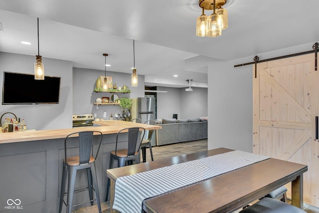 13304 Landwood Dr, Fishers, IN 46037 - dining space with a barn door, wood finished floors, and recessed lighting