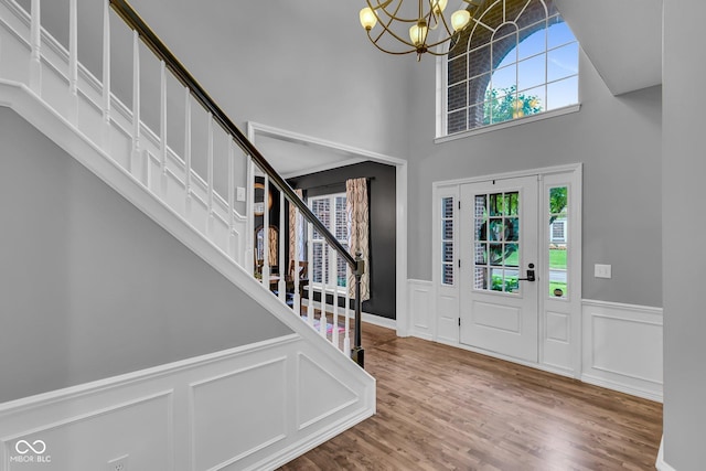 13304 Landwood Dr, Fishers, IN 46037 - foyer entrance featuring stairs, a wainscoted wall, healthy amount of natural light, a chandelier, and wood finished floors