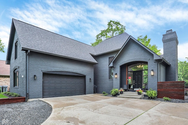 826 N Lanyard Dr, Cicero, IN 46034 - view of front of house featuring a chimney, driveway, a garage, a shingled roof, and brick siding