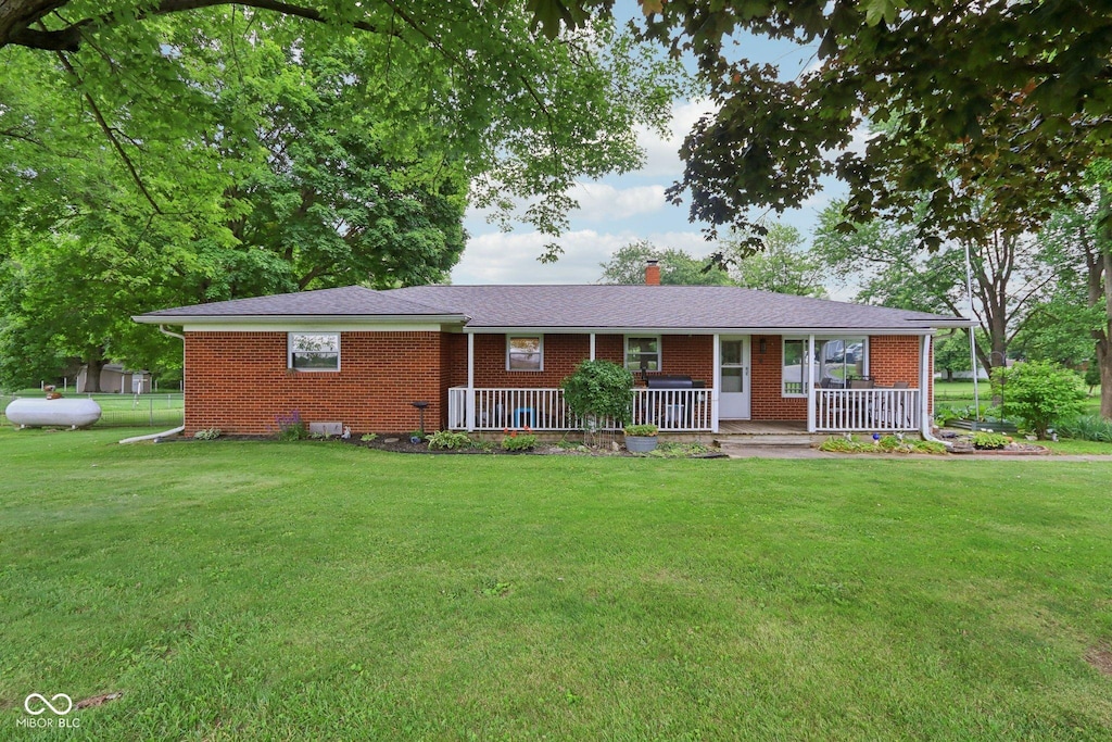 9974 N 850 W, Fairland, IN 46126 - ranch-style house with brick siding, a front lawn, a chimney, and a porch