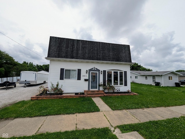 301 W Davis St, Greensburg, IN 47240 - cape cod-style house featuring a front lawn, entry steps, and a shingled roof